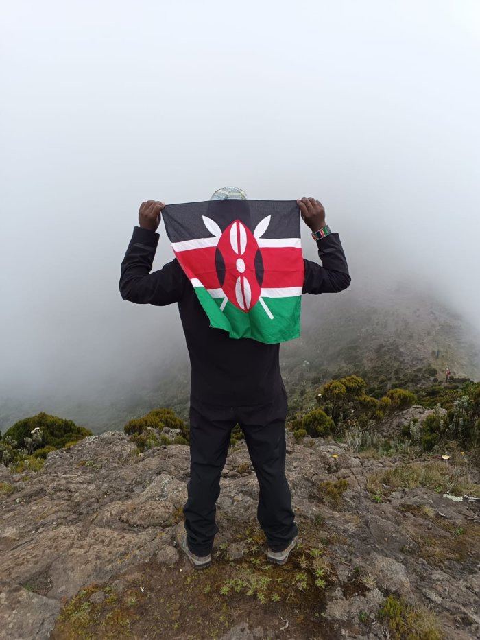 Haron Owalo holding the Kenyan flag